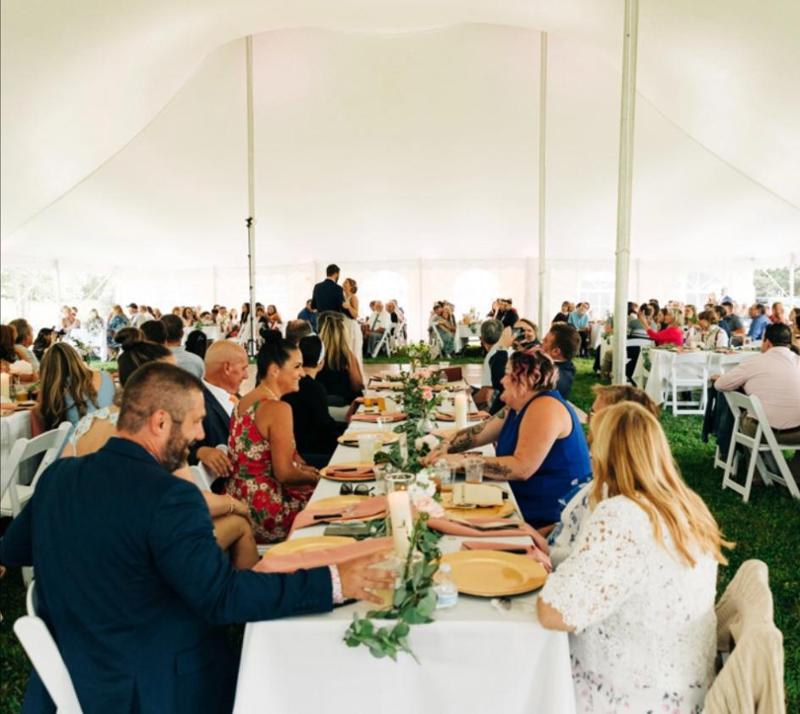 people sitting at long tables, eating